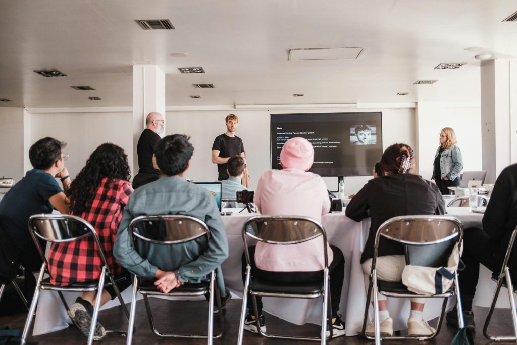 Group of adults in a conference room attending a presentation at work.